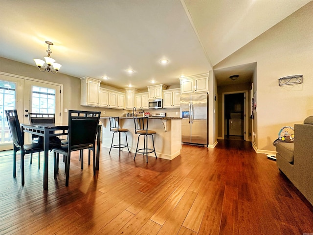 dining room featuring dark wood finished floors, recessed lighting, lofted ceiling, a chandelier, and baseboards