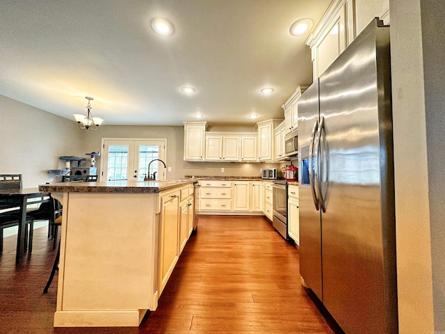 kitchen with a kitchen breakfast bar, dark wood-style flooring, stainless steel appliances, a sink, and recessed lighting