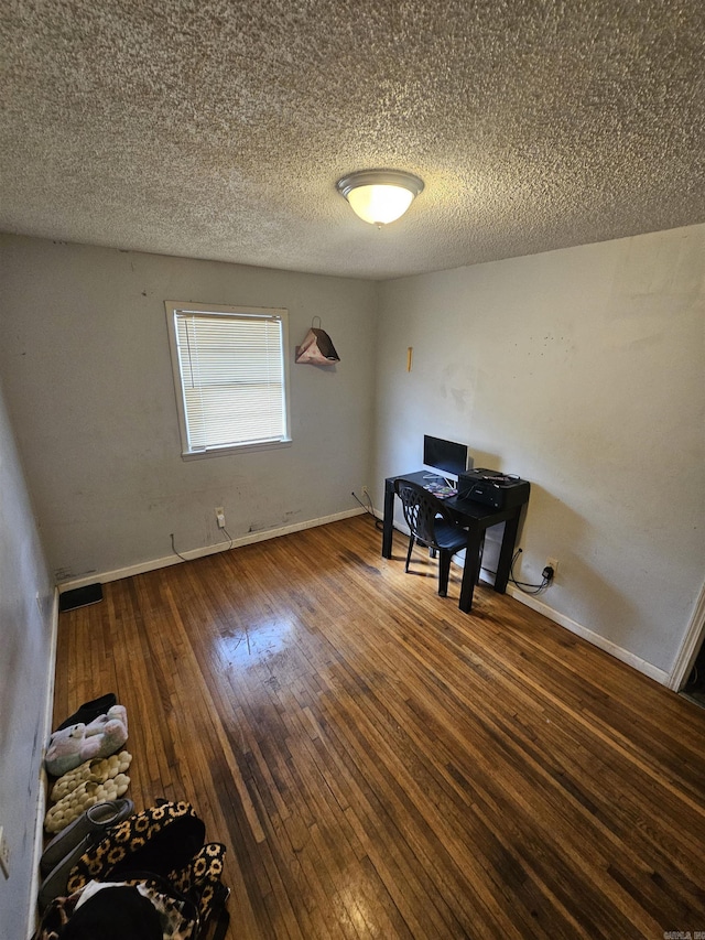 office with wood-type flooring, baseboards, and a textured ceiling