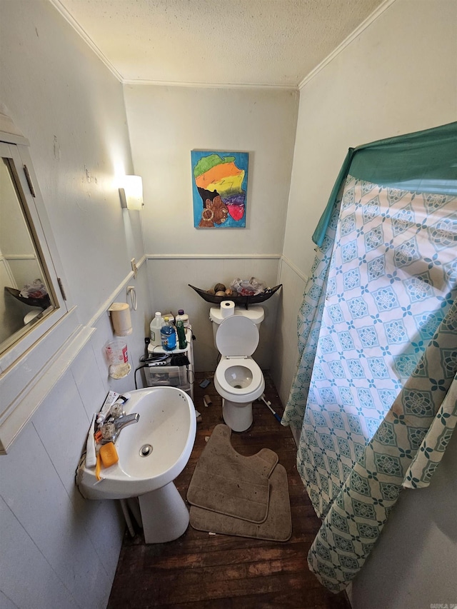 full bathroom featuring a wainscoted wall, crown molding, and a textured ceiling