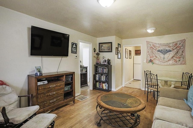 living area with baseboards and wood finished floors