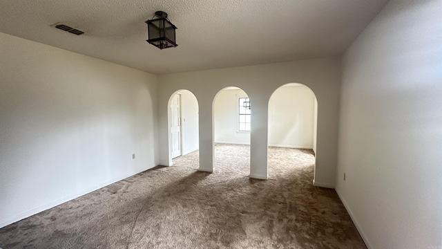 121 W Lee St, Mineral Sprs, AR 71851 - carpeted empty room featuring a textured ceiling, arched walkways, and visible vents