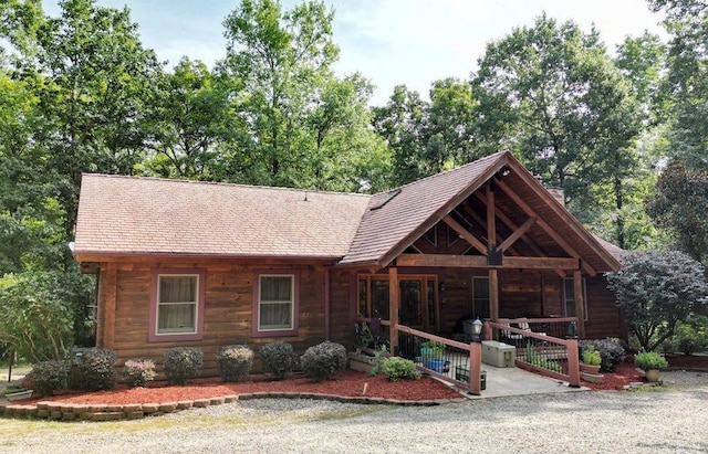 log cabin featuring a porch and log siding