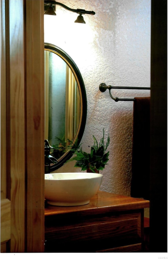 room details featuring a textured wall and vanity