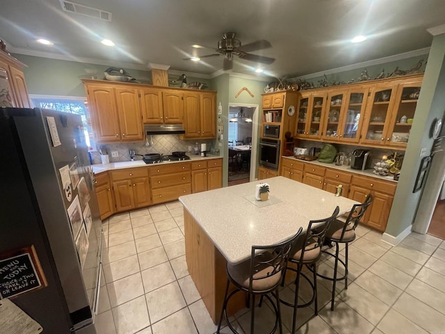 kitchen with visible vents, stainless steel appliances, light countertops, under cabinet range hood, and light tile patterned flooring