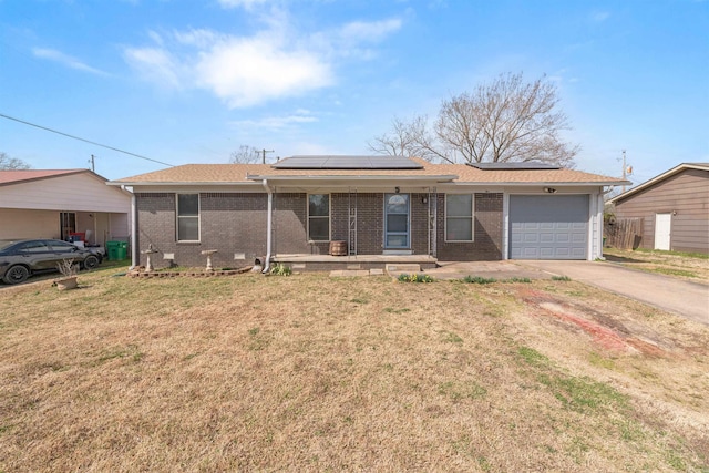 ranch-style house with a garage, brick siding, roof mounted solar panels, and a front yard