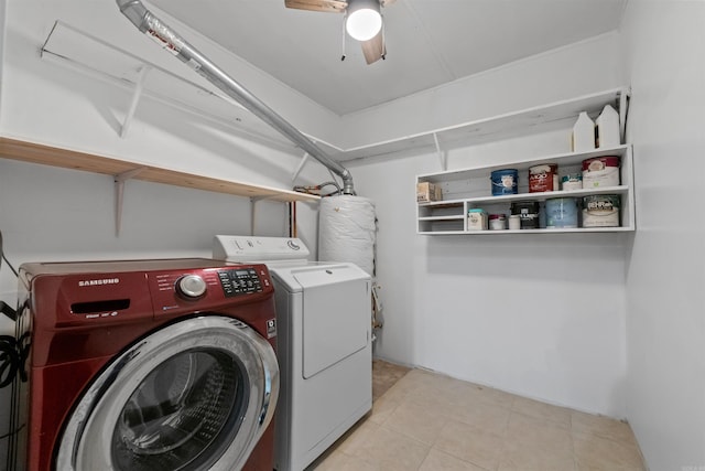 clothes washing area featuring light tile patterned floors, water heater, ceiling fan, separate washer and dryer, and laundry area