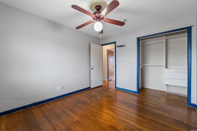 unfurnished bedroom with ceiling fan, a textured ceiling, wood finished floors, baseboards, and a closet