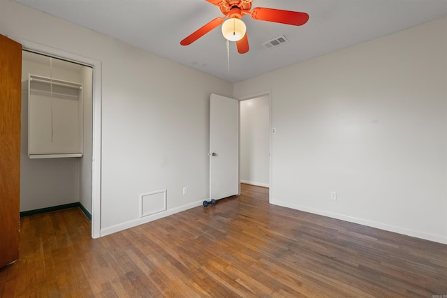 unfurnished bedroom with ceiling fan, wood finished floors, visible vents, baseboards, and a closet