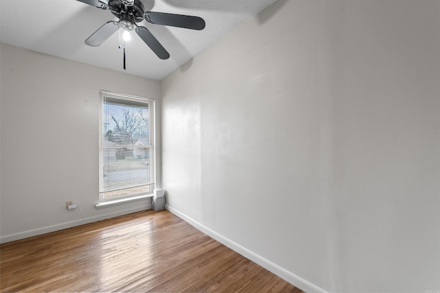 unfurnished room with a ceiling fan, baseboards, and wood finished floors