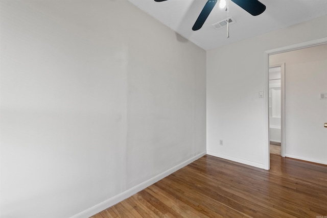 spare room featuring wood finished floors, visible vents, and baseboards