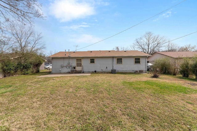 rear view of property featuring entry steps, central AC unit, a lawn, and a patio