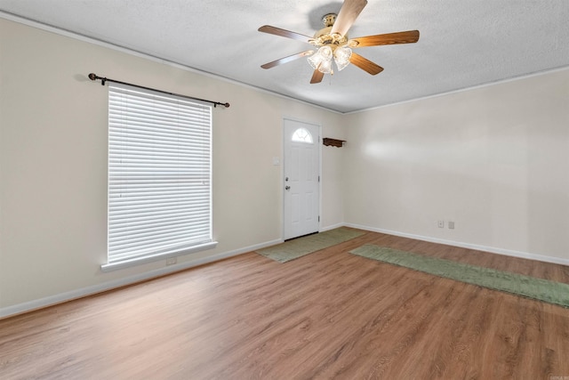 foyer featuring a ceiling fan, plenty of natural light, a textured ceiling, and wood finished floors