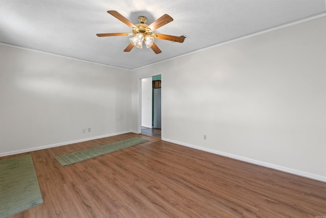 unfurnished room featuring ceiling fan, a textured ceiling, wood finished floors, baseboards, and crown molding