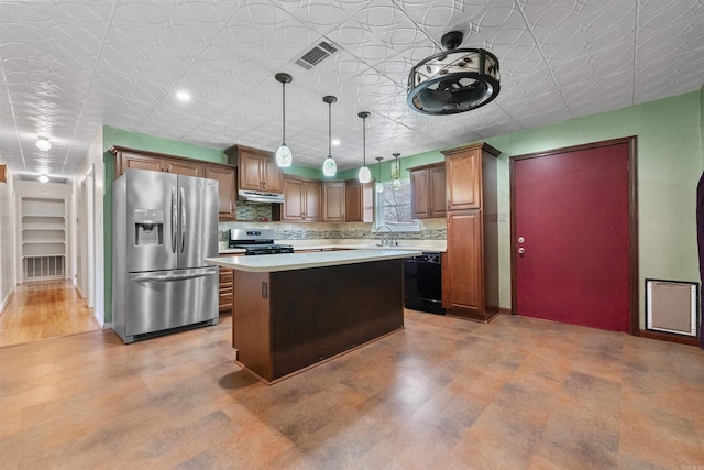 kitchen featuring visible vents, appliances with stainless steel finishes, a center island, light countertops, and under cabinet range hood