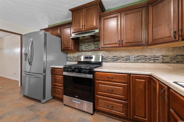 kitchen featuring light countertops, backsplash, appliances with stainless steel finishes, brown cabinetry, and under cabinet range hood