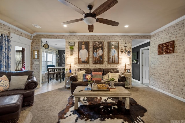 carpeted living area with ceiling fan, recessed lighting, brick wall, baseboards, and ornamental molding