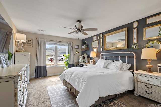 carpeted bedroom with a ceiling fan, visible vents, and baseboards