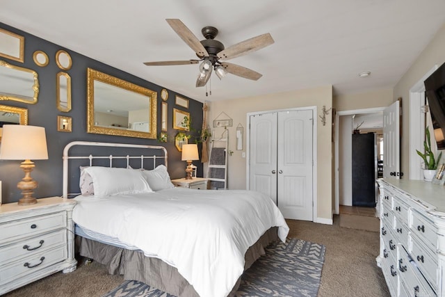 bedroom with a ceiling fan, freestanding refrigerator, a closet, and dark carpet