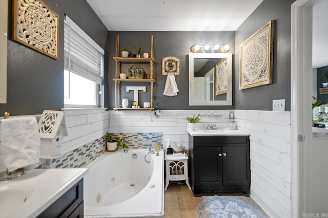 full bath featuring wainscoting, wooden walls, vanity, a jetted tub, and tile patterned floors