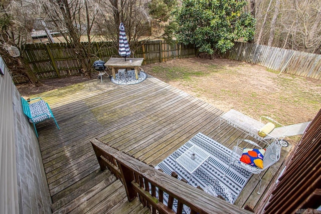 wooden terrace featuring a fenced backyard and a yard