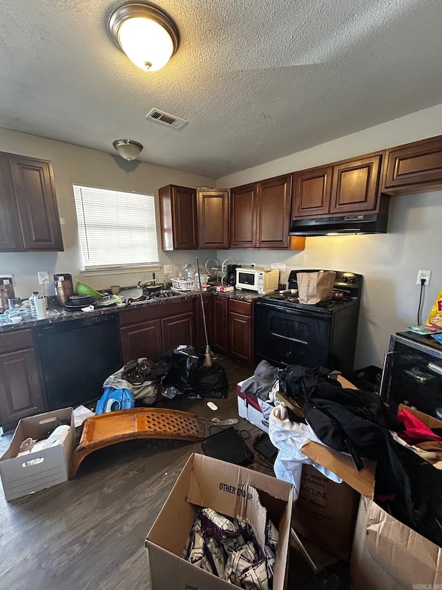 kitchen with under cabinet range hood, stove, visible vents, dark wood-style floors, and dishwasher