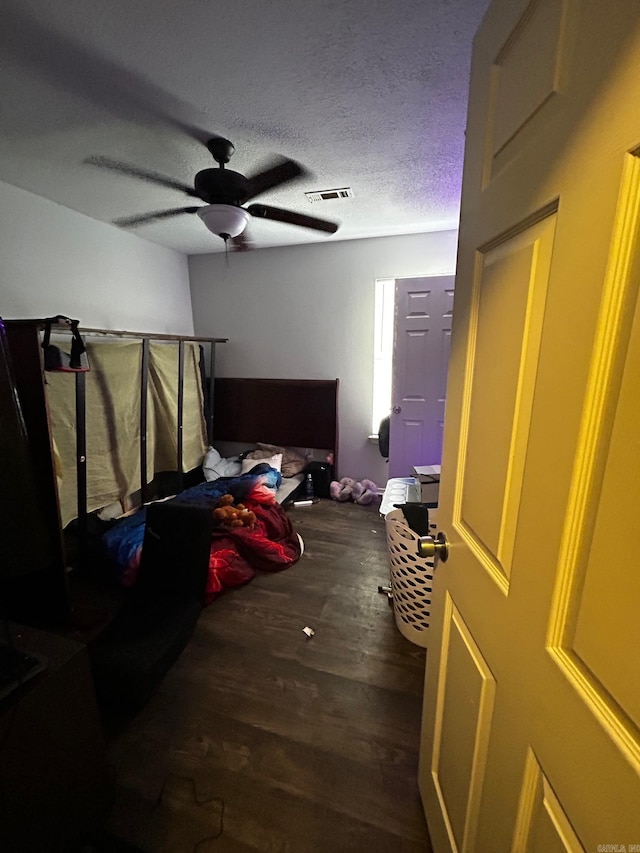 bedroom featuring a textured ceiling, ceiling fan, wood finished floors, and visible vents