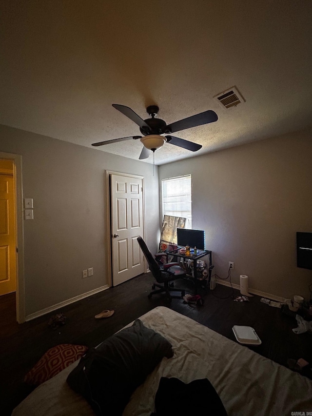 bedroom with ceiling fan, wood finished floors, visible vents, and baseboards