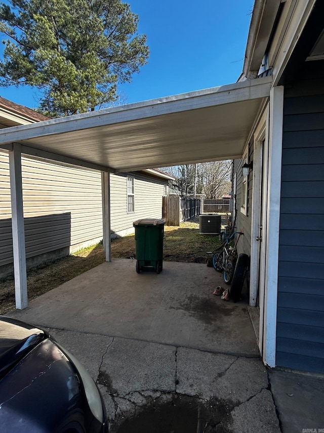 view of patio / terrace featuring a carport, cooling unit, and fence