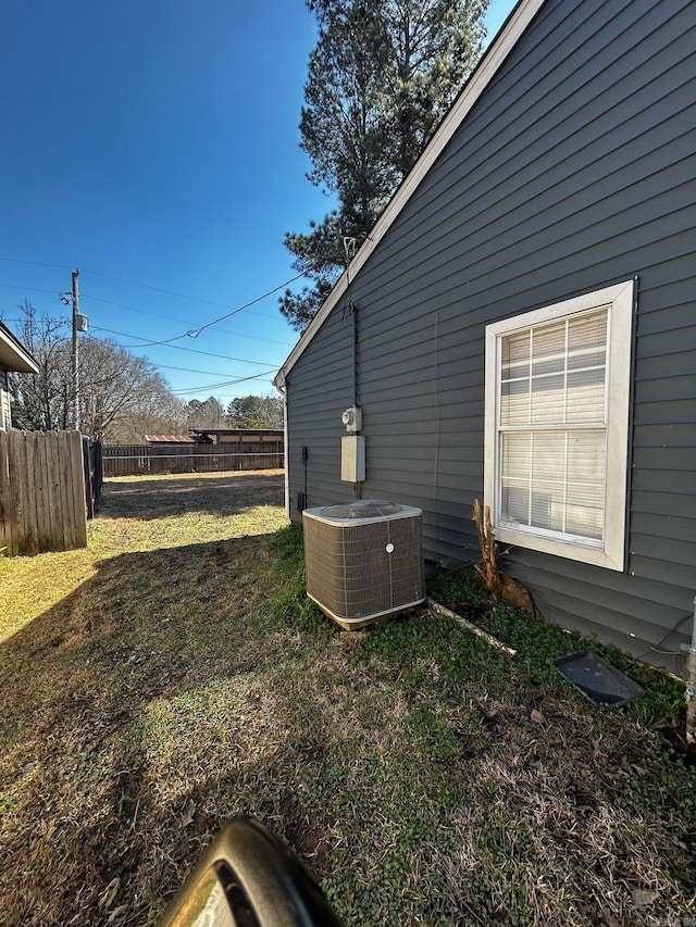 view of yard featuring fence and central AC