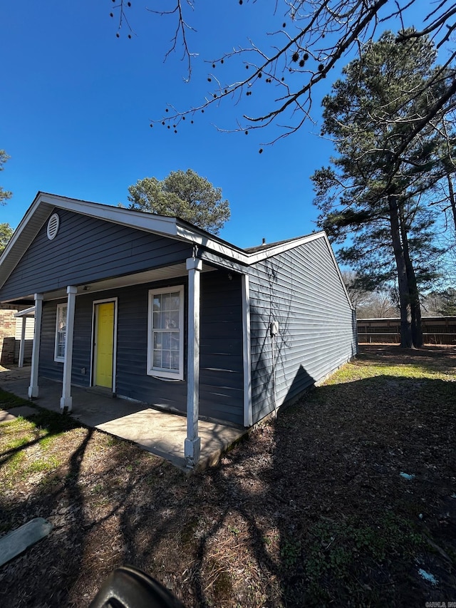 view of front of house with a patio and fence