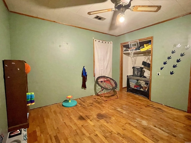 interior space with visible vents, crown molding, and wood finished floors