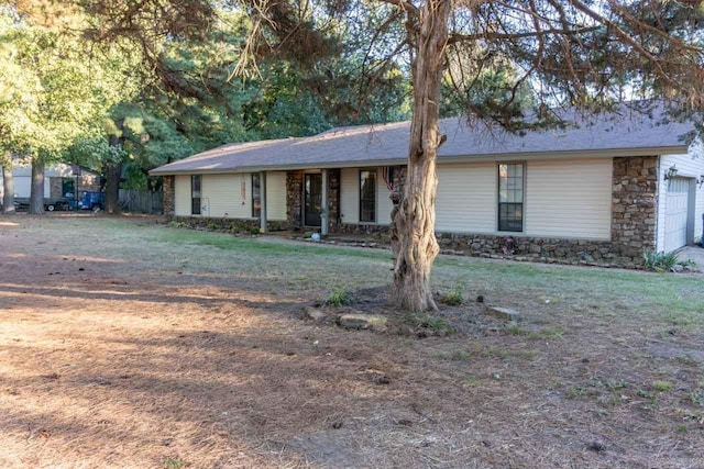 ranch-style house featuring a garage and stone siding