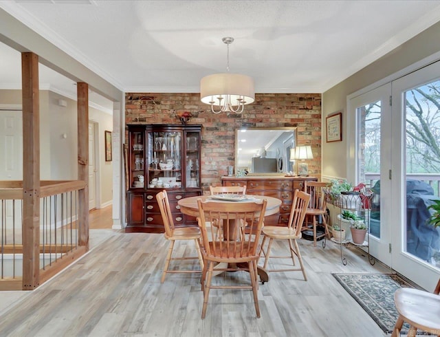 121 Chappel Hill Rd, Hot Springs, AR 71913 - dining room featuring wood finished floors, a chandelier, crown molding, and brick wall