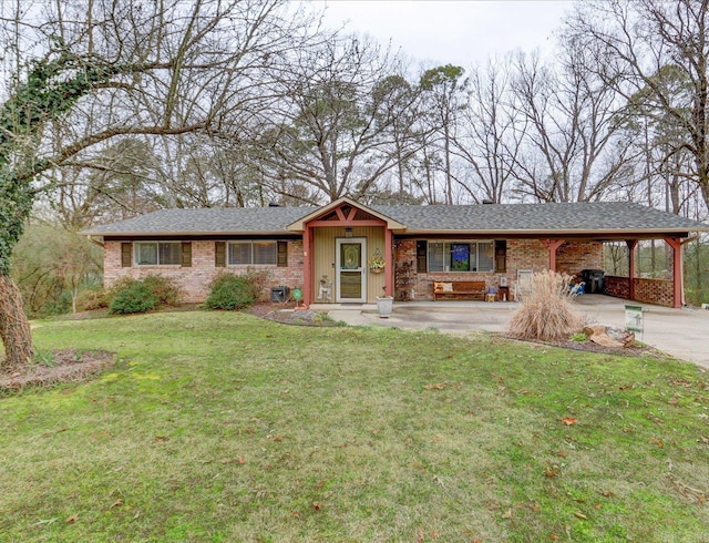 single story home featuring concrete driveway, a carport, a front yard, and brick siding