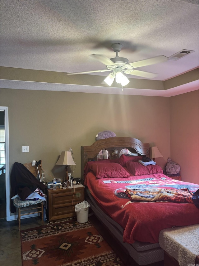 bedroom with a ceiling fan, visible vents, and a textured ceiling