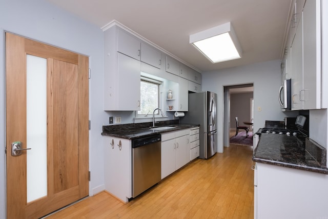 kitchen featuring light wood-style floors, white cabinetry, appliances with stainless steel finishes, and a sink