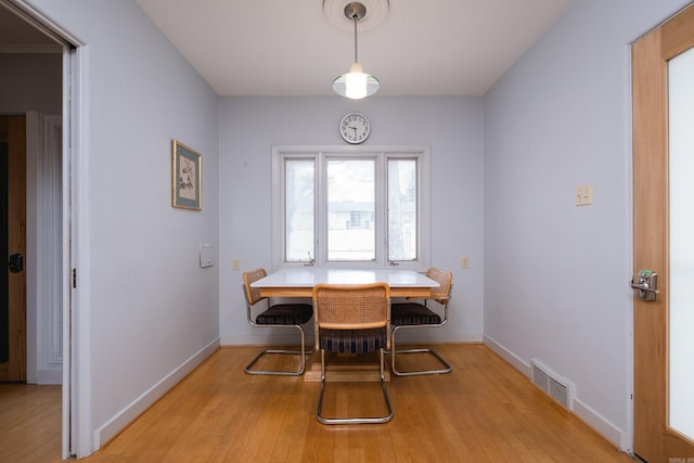 dining space with visible vents, light wood-style flooring, and baseboards