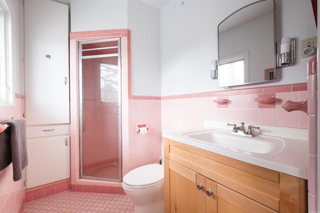 full bathroom featuring tile walls, toilet, wainscoting, a shower stall, and vanity