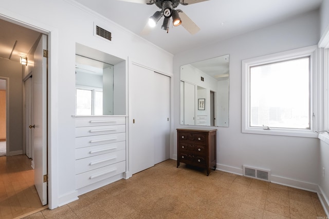 unfurnished bedroom with light floors, visible vents, crown molding, and baseboards