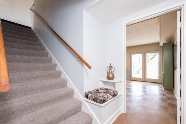 stairway featuring tile patterned floors and french doors