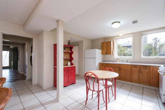 kitchen featuring light countertops, white appliances, visible vents, and plenty of natural light