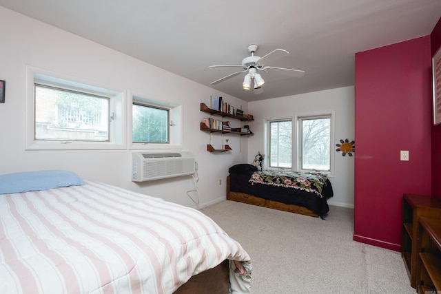 bedroom with an AC wall unit, light colored carpet, ceiling fan, and baseboards