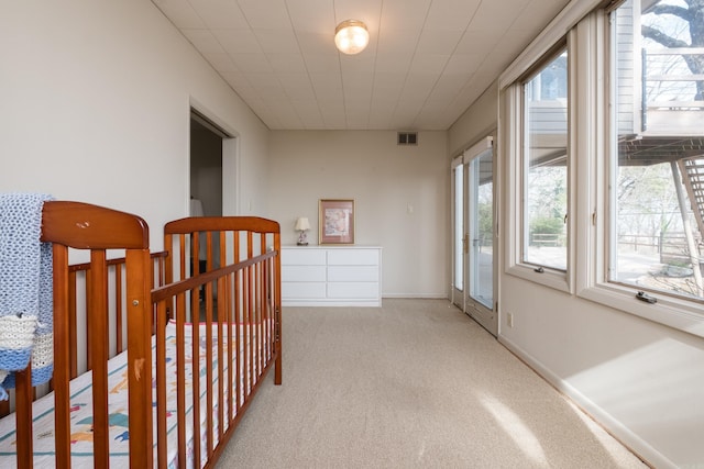 corridor with carpet, visible vents, and baseboards