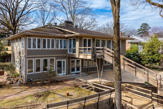 rear view of property with a patio area, a wooden deck, a chimney, and french doors