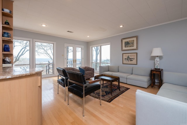 living area with recessed lighting, visible vents, crown molding, and light wood finished floors