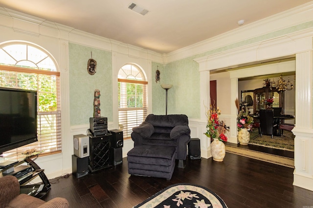 living room with visible vents, dark wood-type flooring, and a decorative wall