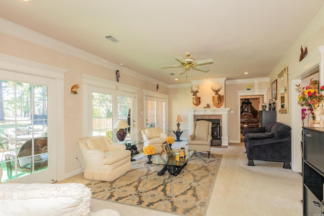 carpeted living room featuring visible vents, a fireplace with raised hearth, crown molding, baseboards, and a ceiling fan