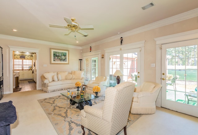 living area with a wealth of natural light, visible vents, and crown molding