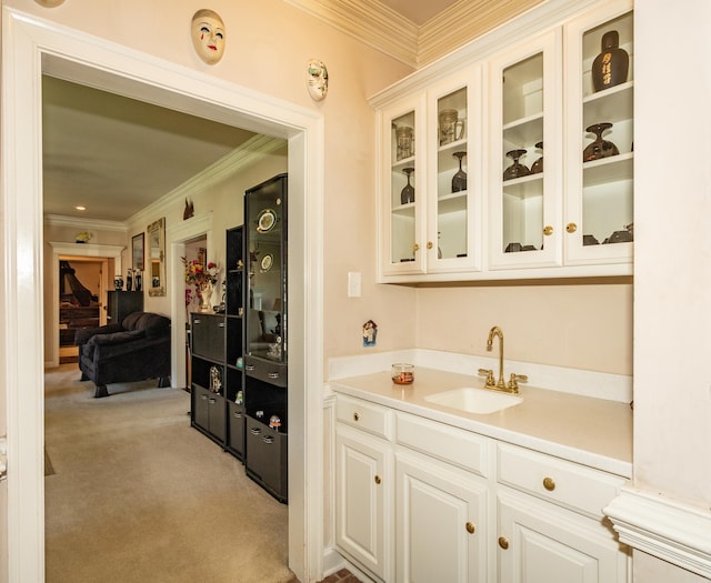 bar featuring crown molding, light carpet, and a sink